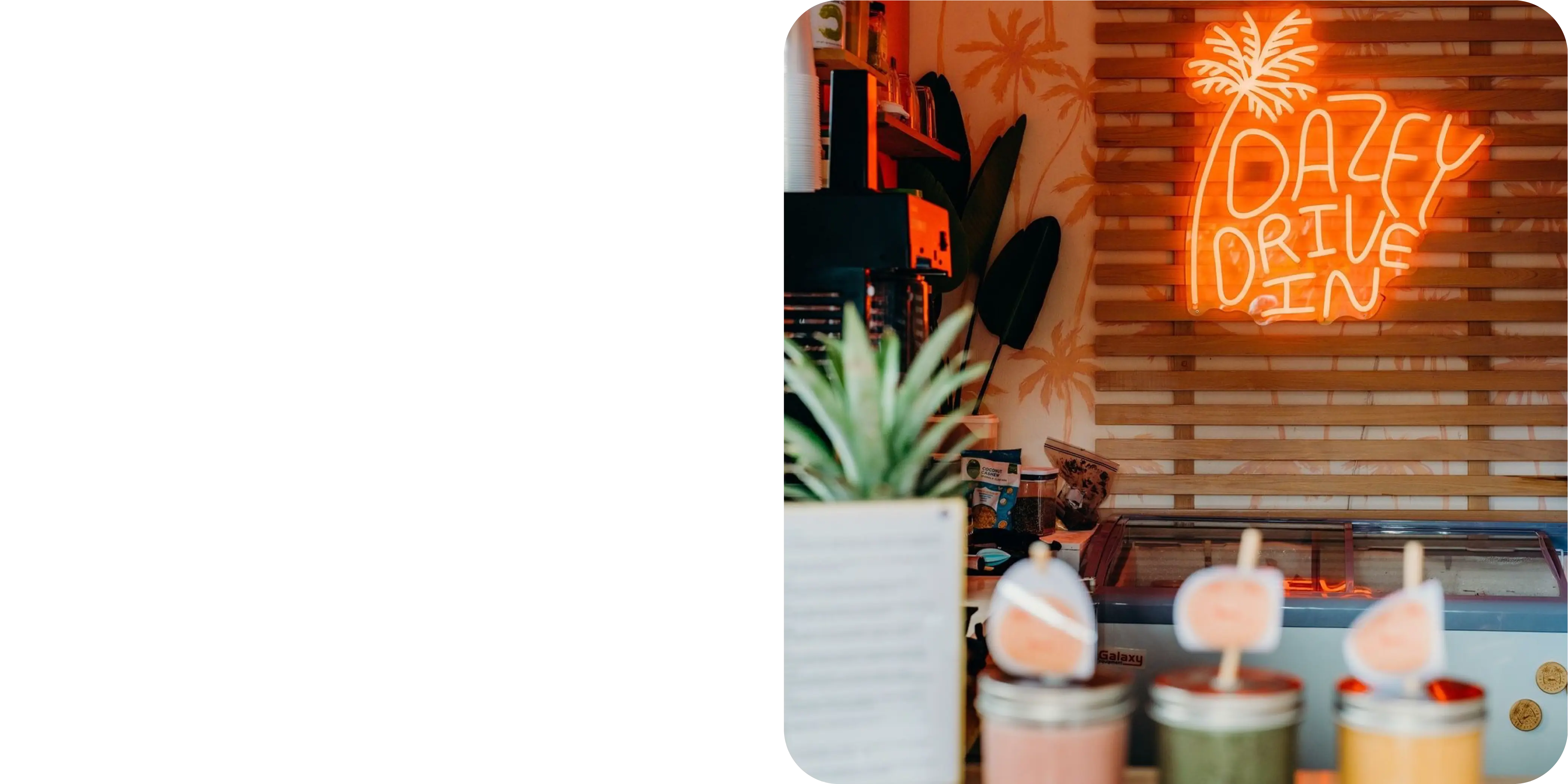 A desk with a computer and neon light heart